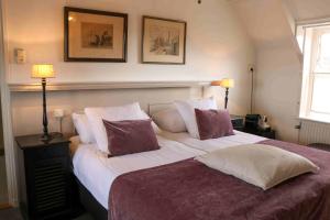 维里坎皮尔萨托伦旅馆的一间卧室配有一张大床,提供紫色和白色枕头