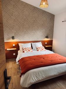 菲加里Chez François et Cécile的一间卧室配有一张带橙色床头板的大床