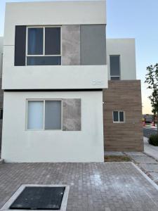 克雷塔罗Casa V25的前面有砖瓦车道的白色房子