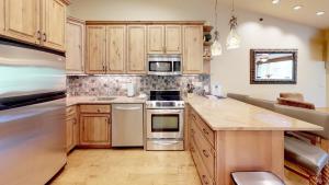 斯诺马斯村Terracehouse - CoralTree Residence Collection的厨房配有木制橱柜和不锈钢用具
