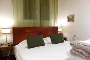 贝尔格莱德Villa Loop Beograd的一间卧室配有两张白色床和绿色枕头