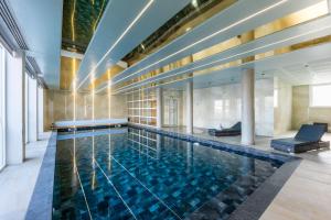 罗尼苏布瓦Brit Hotel Privilège Paris Rosny-sous-Bois的一个带大型游泳池的大房间中的游泳池