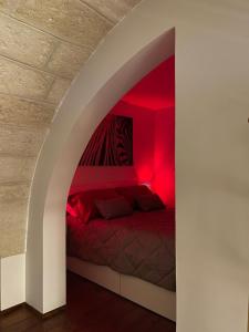 布林迪西Sweet Aura的一间卧室配有红色照明床