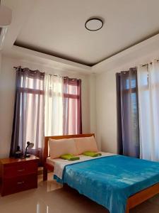 莫阿尔博阿Michael's Apartment的一间卧室配有一张带蓝色床单和窗户的床。