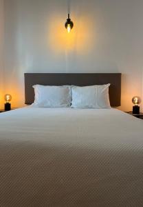奎特里拉Romeu的一间卧室配有带白色枕头和2盏灯的床。