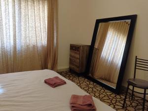 马达巴Jordanian house的一间卧室配有床、镜子和梳妆台