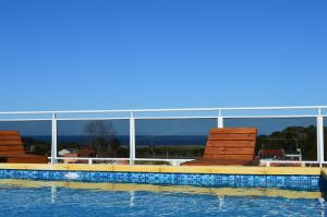 蒙得维的亚巴哈马斯酒店的一座带椅子的游泳池以及一座建筑