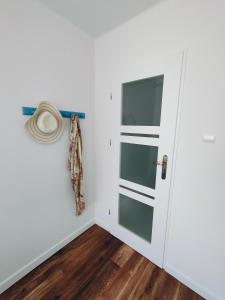 戈莱纽夫Apartament Inka的墙上有一扇门和一顶帽子的房间