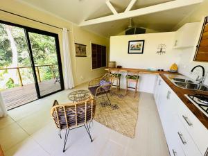 萨武萨武Latui Loft的厨房配有白色橱柜和桌椅