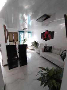 亚美尼亚Habitacion privada en casa familiar con bano compartido的一间白色的客厅,配有白色的沙发,还有一间房间