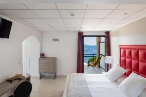维琪奥港罗切布兰切酒店的一间卧室配有一张大床和红色床头板