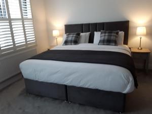 基拉尼Pairc Na Coille Killarney的卧室内的一张大床,配有两盏灯