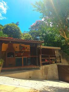 彼得罗波利斯Aconchego de Itaipava - Casa de 3 quartos, ampla, equipada, com área kids, jacuzzi, em meio a Natureza e próximo ao centro do bairro的一个带门廊和围栏的房子