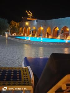 梅尔祖卡阿里摩洛哥传统庭院住宅酒店 的夜间带游泳池的度假村