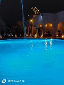 梅尔祖卡阿里摩洛哥传统庭院住宅酒店 的夜间大型蓝色游泳池