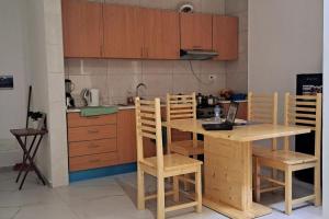 Calheta Do MaioHomestay In Maio - Room for Ladies, Couples & Families only, please的厨房配有木制橱柜和桌椅