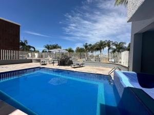莱昂InHouse León的蓝色的游泳池,拥有白色的围栏和棕榈树