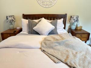 NundaLetchworth Farm Guesthouses的一间卧室配有带白色床单和枕头的床。
