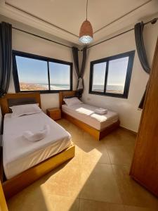 阿加迪尔Baya House Sea View的一间卧室设有两张床和两个窗户。