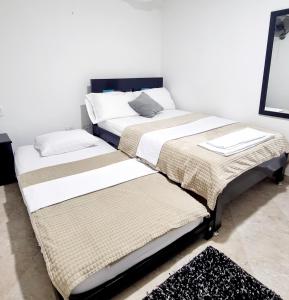 布卡拉曼加Hermosa casa en Bucaramanga的两张睡床彼此相邻,位于一个房间里