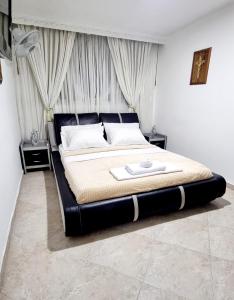 布卡拉曼加Hermosa casa en Bucaramanga的一间卧室配有一张大床和黑色床头板
