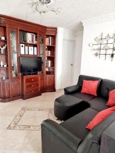布卡拉曼加Hermosa casa en Bucaramanga的客厅配有黑色沙发和电视