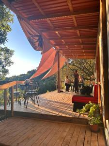 PoásCasa Monte Armadillo的木制甲板上设有遮阳篷和桌椅