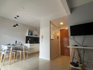 罗萨里奥Premium Apartment Rosario - Joan Miró的厨房以及带桌子和电视的用餐室。