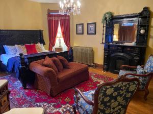 圣约瑟夫Vineyard Mansion B&B的一间卧室配有一张床、一张沙发和一把椅子