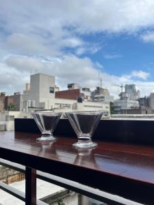 罗萨里奥Premium Apartment Rosario - Joan Miró的两杯玻璃坐在桌子上,享有城市美景