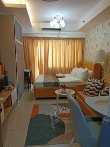 马尼拉Shell Residences by Amonbrey Suite nr airport的一间卧室配有一张床,客厅配有沙发