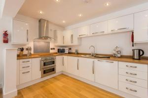Saint BrewardJubilee Cottage - Cwc75016的厨房配有白色橱柜和不锈钢用具