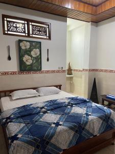 八丹拜Bagus Homestay的一间卧室配有一张带蓝色棉被的床