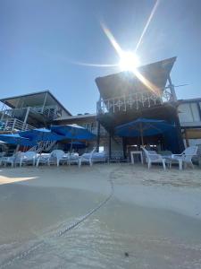 布兰卡滩MAR AZUL ISLA BARU, RESTAURANTE HOTEL.的海滩上的一组椅子和遮阳伞