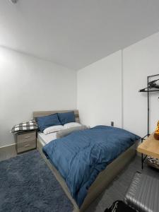 Ấp Rạch MẹoCăn hộ 2 phòng ngủ tầng 17 Sophia Center的一间卧室配有一张带蓝色床单的床和一张书桌。