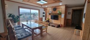 济州市나무집 게스트하우스的客厅配有桌子和沙发