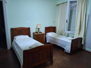 派桑杜Casona Harguindeguy的一间卧室设有两张床和窗户。
