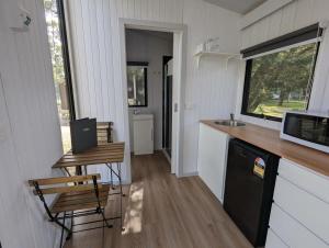 Dadswells BridgeTiny House 15 at Grampians Edge的一个小房子里的厨房,配有柜台和水槽