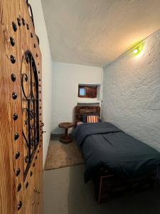 IzilaneGîte de montagne Azilane的一间卧室设有一张床和木墙