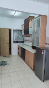 加影Eing's Homestay - Muslim And Mahram Only的厨房配有木制橱柜和不锈钢冰箱。