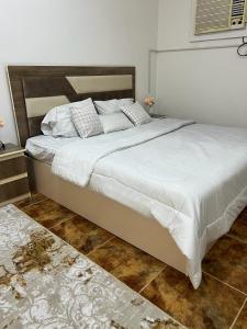 Sīdī Ḩamzahالعلم نور的一间卧室配有一张带白色床单的大床