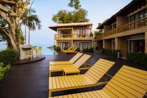 苏梅岛Sea Sun Bed & Beyond的一个带黄色长椅的甲板和一座建筑
