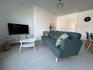 拉罗谢尔Appartement La Rochelle, 4 pièces, 8 personnes - FR-1-246-698的客厅配有蓝色的沙发和电视