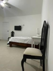 巴尼Casa Zanelli, lugar de paz…的卧室配有1张床、1张桌子和1把椅子
