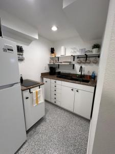 夏延Basement Bliss: Cozy Getaway的厨房配有白色橱柜和白色冰箱。