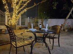 孟丰沙湾Sipanya Guesthouse的一张桌子、两把椅子和一瓶葡萄酒