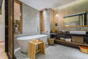 丽江Xisu Garden Inn Lijiang的带浴缸和盥洗盆的浴室