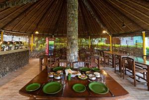 加尔加Corbett Wild Resorts & Spa的一间用餐室,配有一张带绿盘的桌子