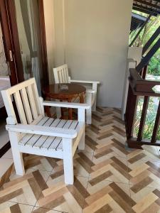涛岛海滩之风度假村的一间设有两把白色椅子和一张桌子的房间