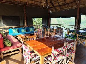 波特尔堡Mwamba Kelele Lodge的一间带木桌和椅子的用餐室